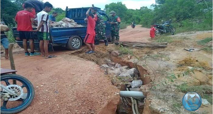 Anggota TNI Timbun Jalan Longsor Akibat Hujan di Moro