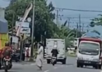 Viral Video Seorang Pria Bergamis Solat Ditengah Jalan Raya