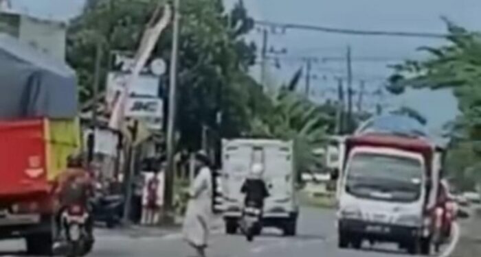 Viral Video Seorang Pria Bergamis Solat Ditengah Jalan Raya