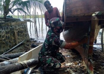 Babinsa Paoh Bantu Warganya Sedang Perbaikan Pompong Nelayan