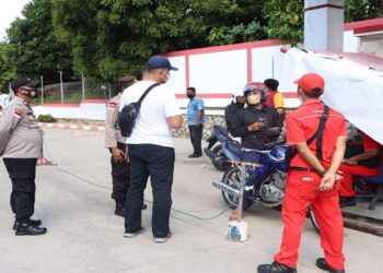 Kapolres Karimun Memberikan Minyak Pertalite Gratis Kepada Pengendara Bermotor Yang Ingin Vaksin