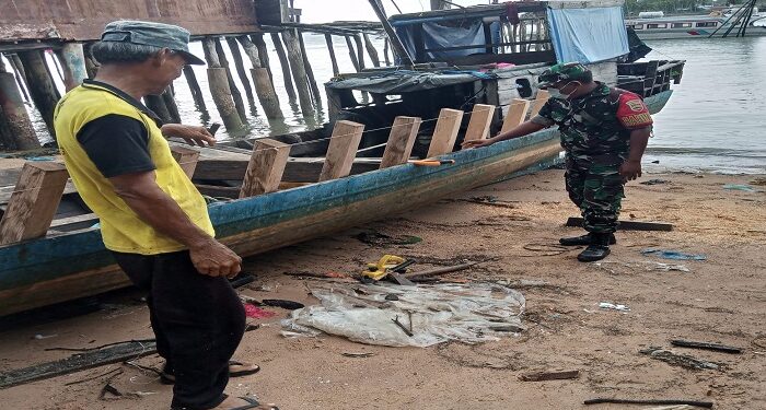 Komsos Babinsa Serda Guslim Ke Warga Sedang Rehab Pompong Nelayan Di Desa Sugie