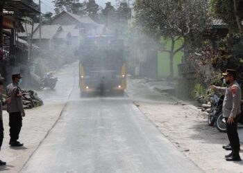 Polisi Bantu Warga Bersihkan Abu Vulkanik