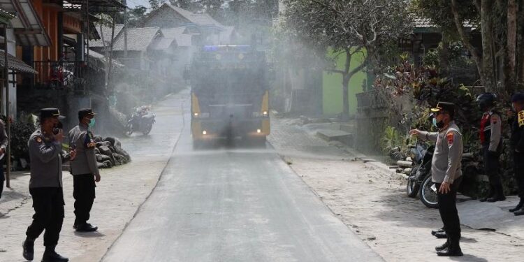 Polisi Bantu Warga Bersihkan Abu Vulkanik