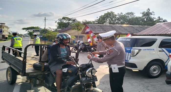 Semarak HUT RI ke-78, Polantas Polres Lingga Bagikan Bendera Merah Putih Kepada Pengendara Sepeda Motor