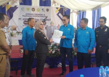 Kepala Balai Karantina Hewan, Ikan dan Tumbuhan Kepulaualan Riau (Karantina Kepri) saat memberikan sertifikasi jaminan kesehatan pada komoditas santan kelapa kepada Direktur Suratno sebagai penanggung jawab PT Kepri central coconut ( PT.KCC).